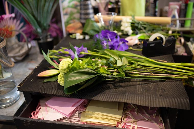 Flowers and wrapping paper laid out on a florist's bench