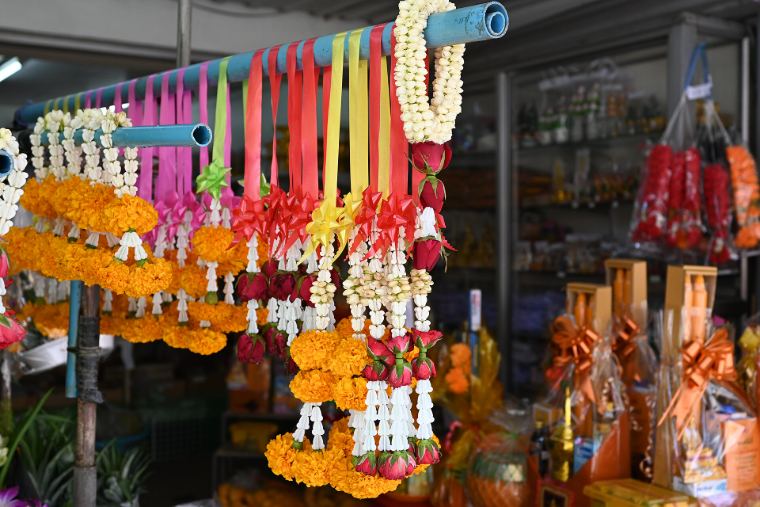 Marigold and jasmine garlands hanging at a flower stall